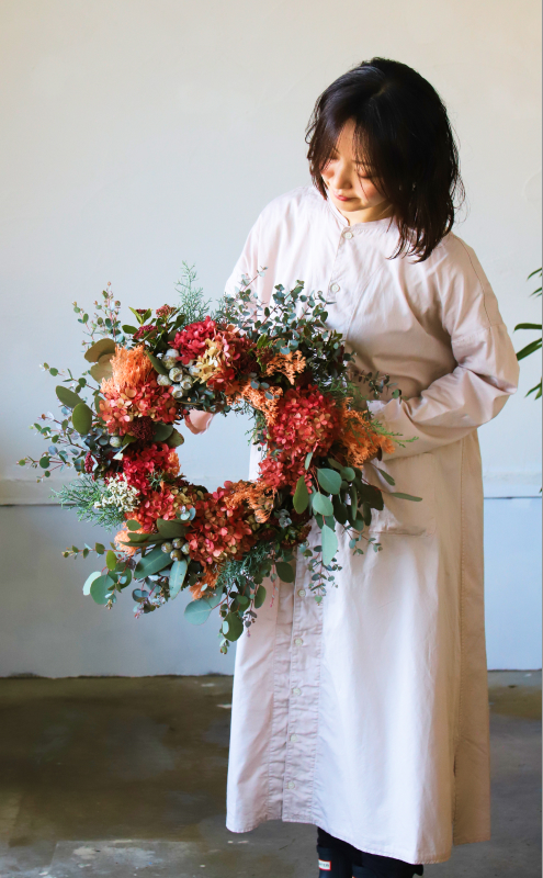女性がフラワーリースを持っている